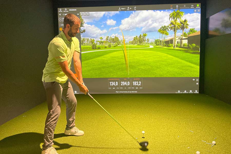 Martin Harnik steht in einer In-door Golfsimulator schlagbereit