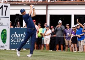 Jordan Spieth schlägt ein Golfball, im Hintergrund stehen Fans