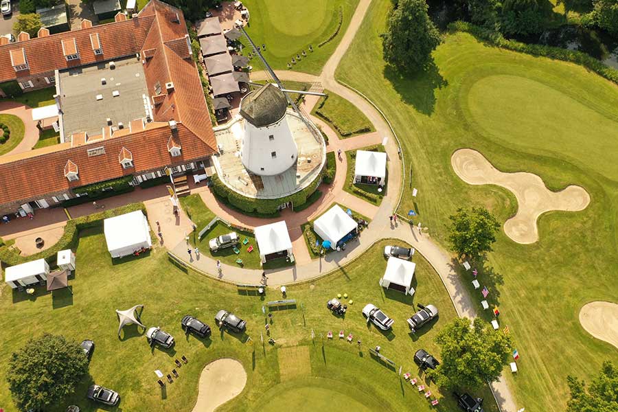 Ein Golfplatz aus der Vogelperspektive, in der Mitte eine Mühle.