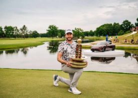 Ein Golfer mit Pokal vor einem Wasserhinderniss und ein Porsche im Hintergrund