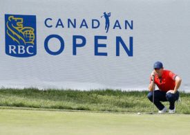 Rory McIlroy hockt vor dem RBC Canadan Open Logo