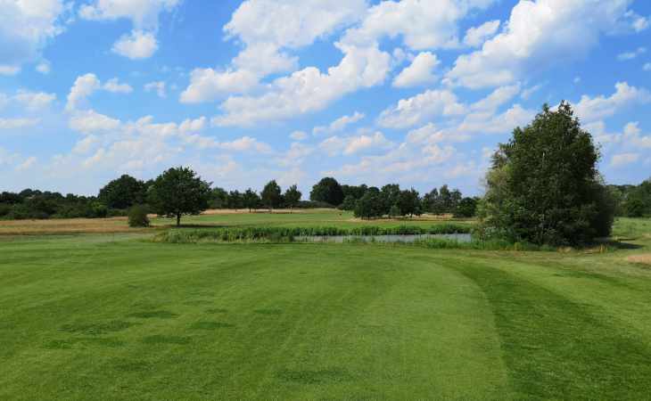 Ein blauer Himmel mit Wolken über einem Golfplatz