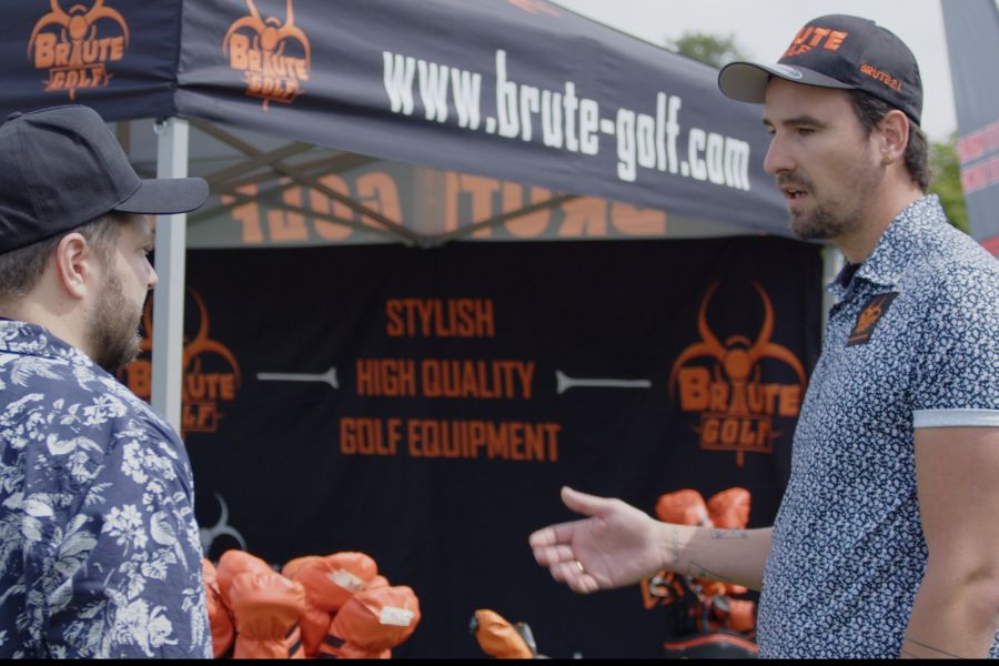 Zwei Golfer sprechen vor einem Messestand