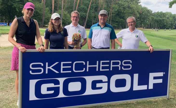 Fünf Golfer hinter einem Skechers Reklame-Schild