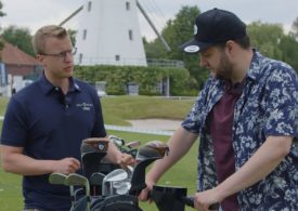 Ein Mann auf einem Golf Scooter spricht mit einem anderen Mann