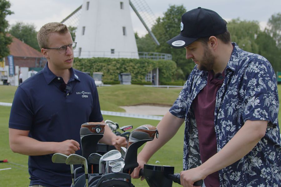 Ein Mann auf einem Golf Scooter spricht mit einem anderen Mann