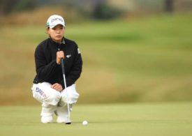 Golferin Hinako Shibuno in der Hocke vor ihrem Golfball