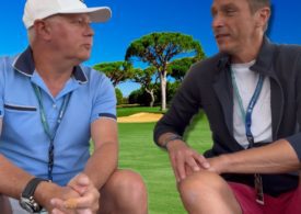 Zwei Männer unterhalten sich vor einem Golfplatz