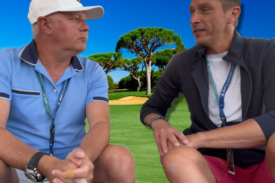 Zwei Männer unterhalten sich vor einem Golfplatz