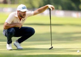 Golfer Stephan Jäger in der Hocke schaut einem Ball hinterher