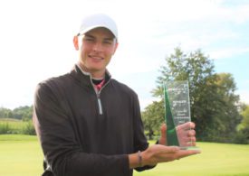 Ein Golfer hält einen Pokal