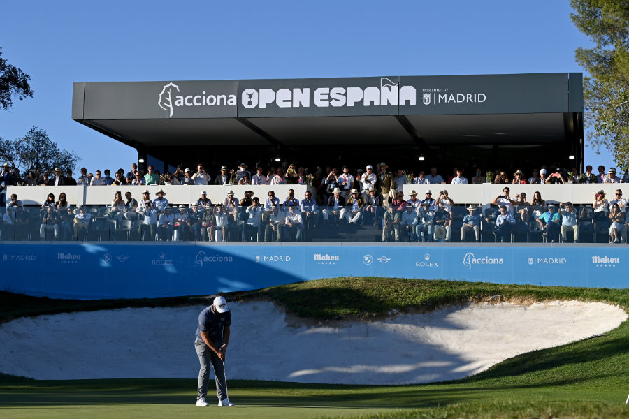 Ein Golfer vor einem Sandbunker, dahinter eine Zuschauer-Tribüne