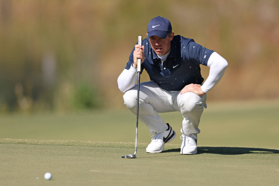 Golfer Rory McIlroy verfolgt hockend seinen Ball