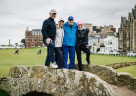 Vier Menschen auf der Swilcan Bridge in St. Andrews