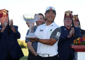 Ein Golfer hält einen Pokal