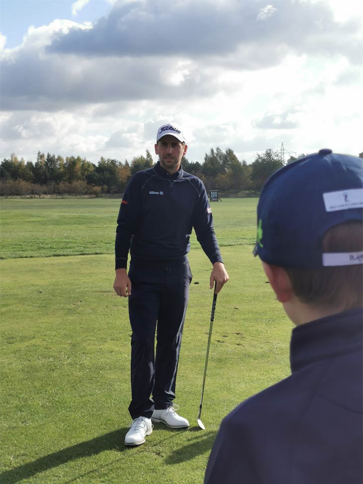 Ein Golfer der mit einem Golfschläger auf einem Golfplatz steht