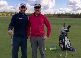 Zwei Golfer die nebeneinander auf einem Golfplatz stehen