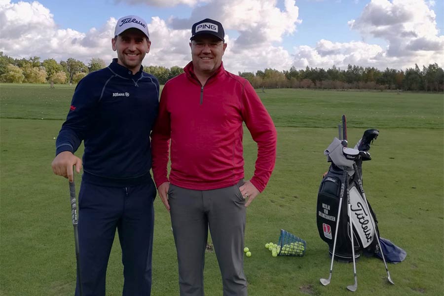 Zwei Golfer die nebeneinander auf einem Golfplatz stehen