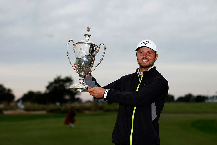 Adam Svensson hält den Pokal vom RSM Classic 2022 hoch