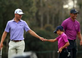 Justin Thomas gibt Charlie Woods die Faust, Tiger Woods lächelt dahinter