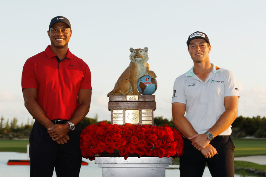 Tiger Woods und Viktor Hovland stehen neben einer Trophäe