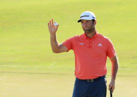 Der Golfspieler Jon Rahm hält ein Golfball hoch und guckt enttäuscht