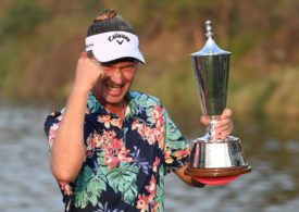 Golfer Marcel Siem mit gereckter Faust und einer Trophäe