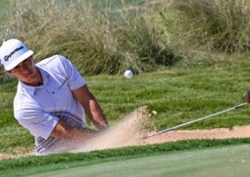 Der Golfspieler Thorbjorn Olesen schlägt ein Golfball auf einem Sandfeld