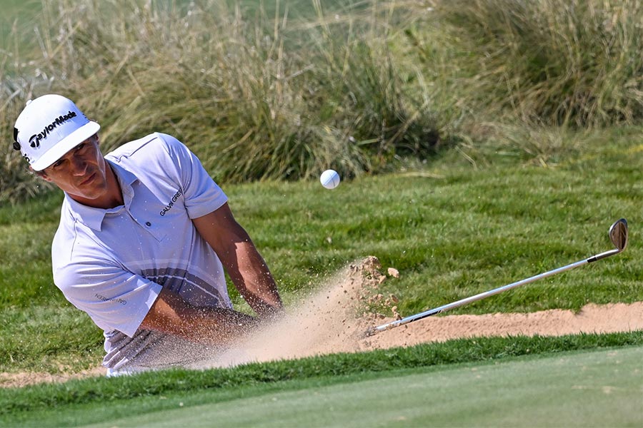Der Golfspieler Thorbjorn Olesen schlägt ein Golfball auf einem Sandfeld