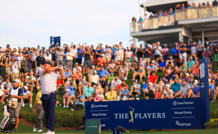 Golfer Bryson DeChambeau beim Abschlag vor der Werbetafel von The Players und vielen Fans