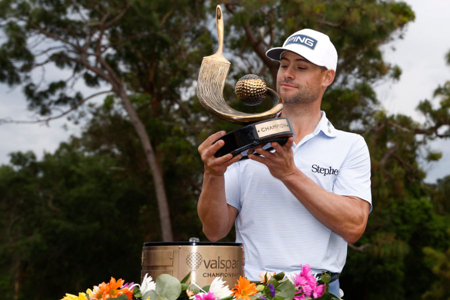 Ein Golfer betrachtet seine Trophäe