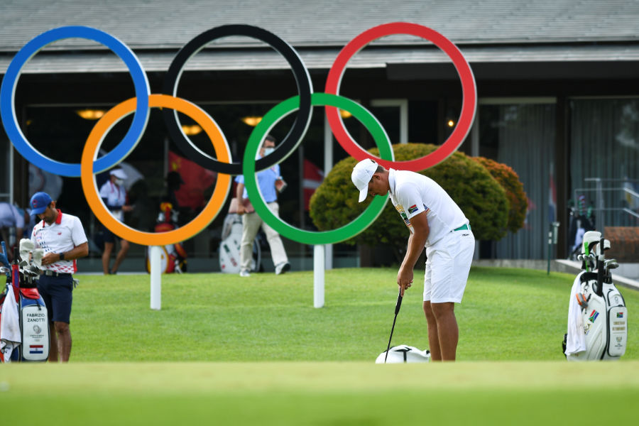 Ein Golfer puttet vor den olympischen Ringen