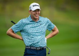Der Golfspieler Alex Knappe lächelt und hat seine Hände an seiner Hüfte