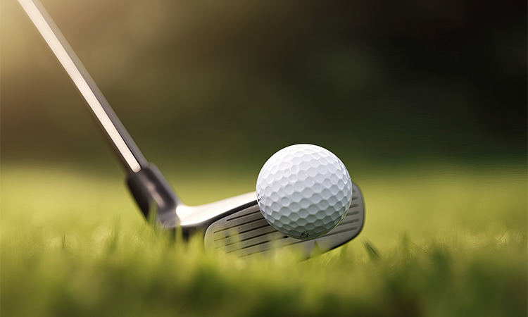 Ein Bild von einem Golfschläger und einem Golfball auf der Wiese