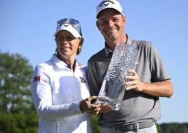 Der Golfspieler Dale Whitnell und die Golfspielerin Annika Sorenstam stehen nebeneinander uns halten zusammen ein Pokal