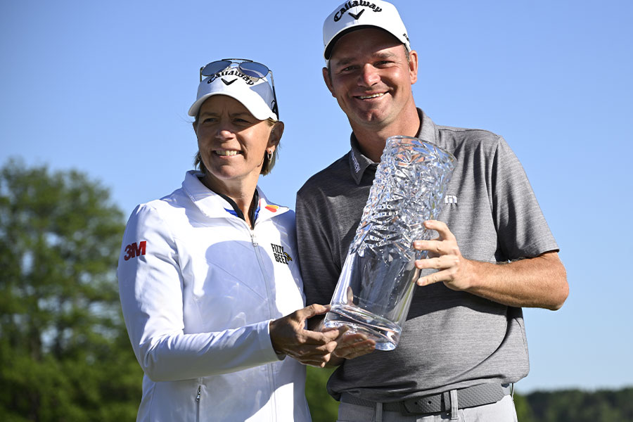 Der Golfspieler Dale Whitnell und die Golfspielerin Annika Sorenstam stehen nebeneinander uns halten zusammen ein Pokal