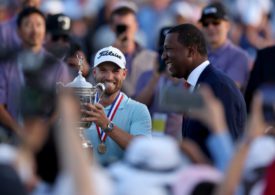 Golfer Wyndham Clark hält eine Trophäe hoch