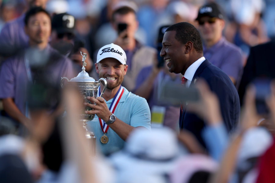 Golfer Wyndham Clark hält eine Trophäe hoch