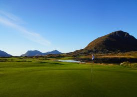 Ein Golfplatz mit Bergen im Hintergrund