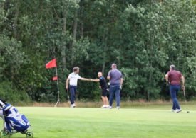 Golfer geben sich am Loch einen Fistbump