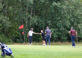 Golfer geben sich am Loch einen Fistbump