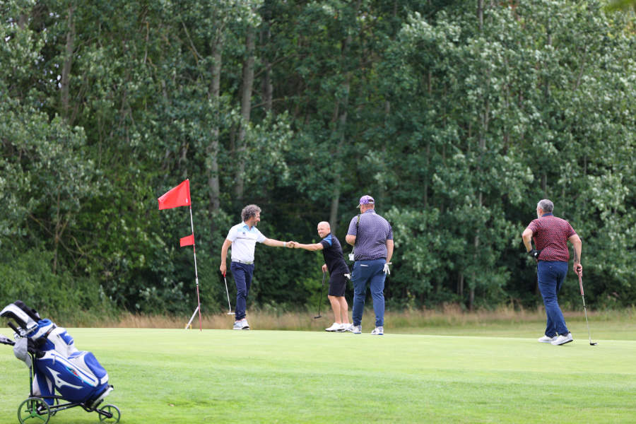 Golfer geben sich am Loch einen Fistbump