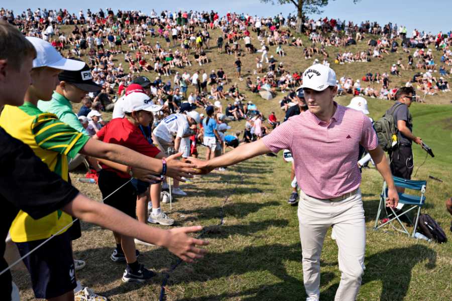 Ein Golfer klatscht mit Zuschauern ab