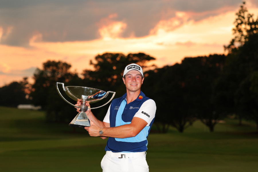 Viktor Hovland posiert mit dem FedExCup in der Abendsonne