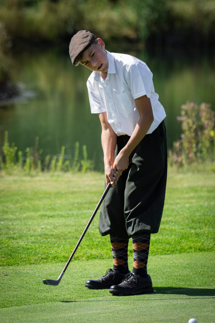 Ein junger Hickory-Golfer beim Putt