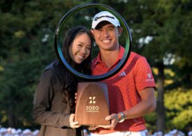 Golfer Collin Morikawa präsentiert eine Trophäe mit seiner Ehefrau