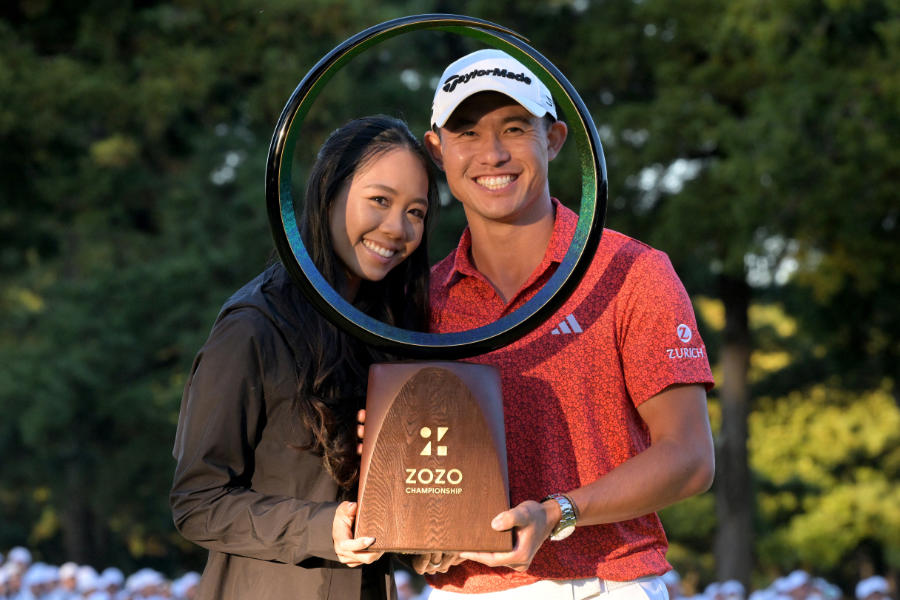 Golfer Collin Morikawa präsentiert eine Trophäe mit seiner Ehefrau