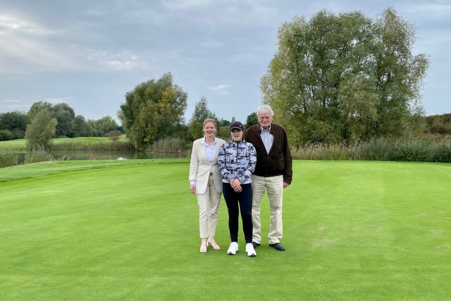 Drei Personen auf einem Golfplatz