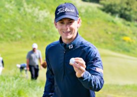 Ein Golfer hält einen Golfball in die Kamera