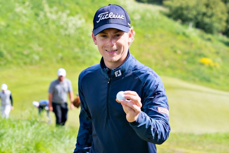 Ein Golfer hält einen Golfball in die Kamera